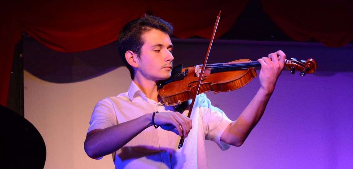 Un ado violoniste concentré pendant son concert